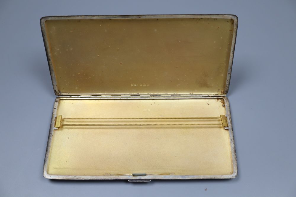 Three assorted mid 20th century silver engine turned cigarette cases, largest 16.8cm, gross 18oz.